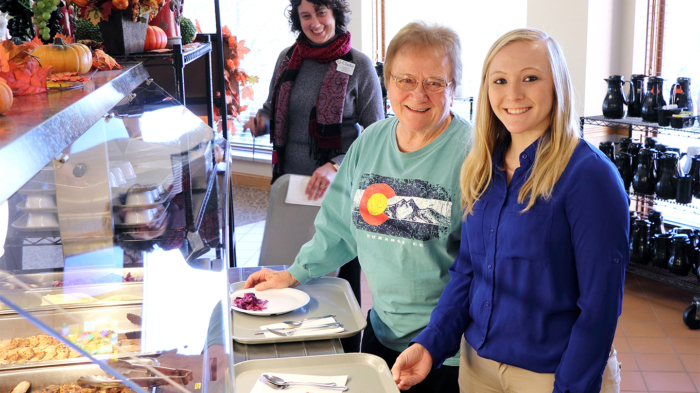 A Clarke University professor and student shares a meal with Georgeann (Immaculate) Quinlan, BVM (middle) at Mount Carmel.