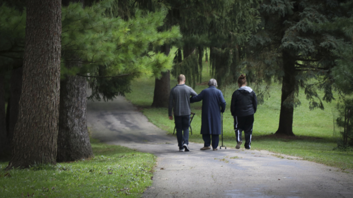 Clarke University students accompany sisters in wheelchairs and walkers to the Mount Carmel cemetery to visit their dear friends.