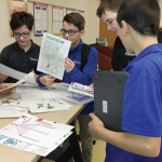Students at Mazzuchelli Middle School in Dubuque study drawings from Haitian students depicting images of life in Medor, Haiti.